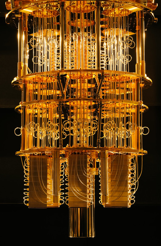 The image is of IBM's Quantum Computer, relating to quantum computing and AI 